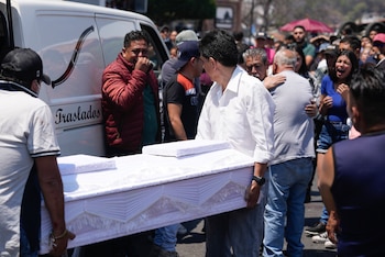 Trabajadores de la funeraria cargan