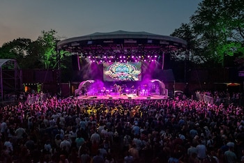 Las luces, la música en vivo y el público llenan el escenario de SummerStage en Rumsey Playfield.