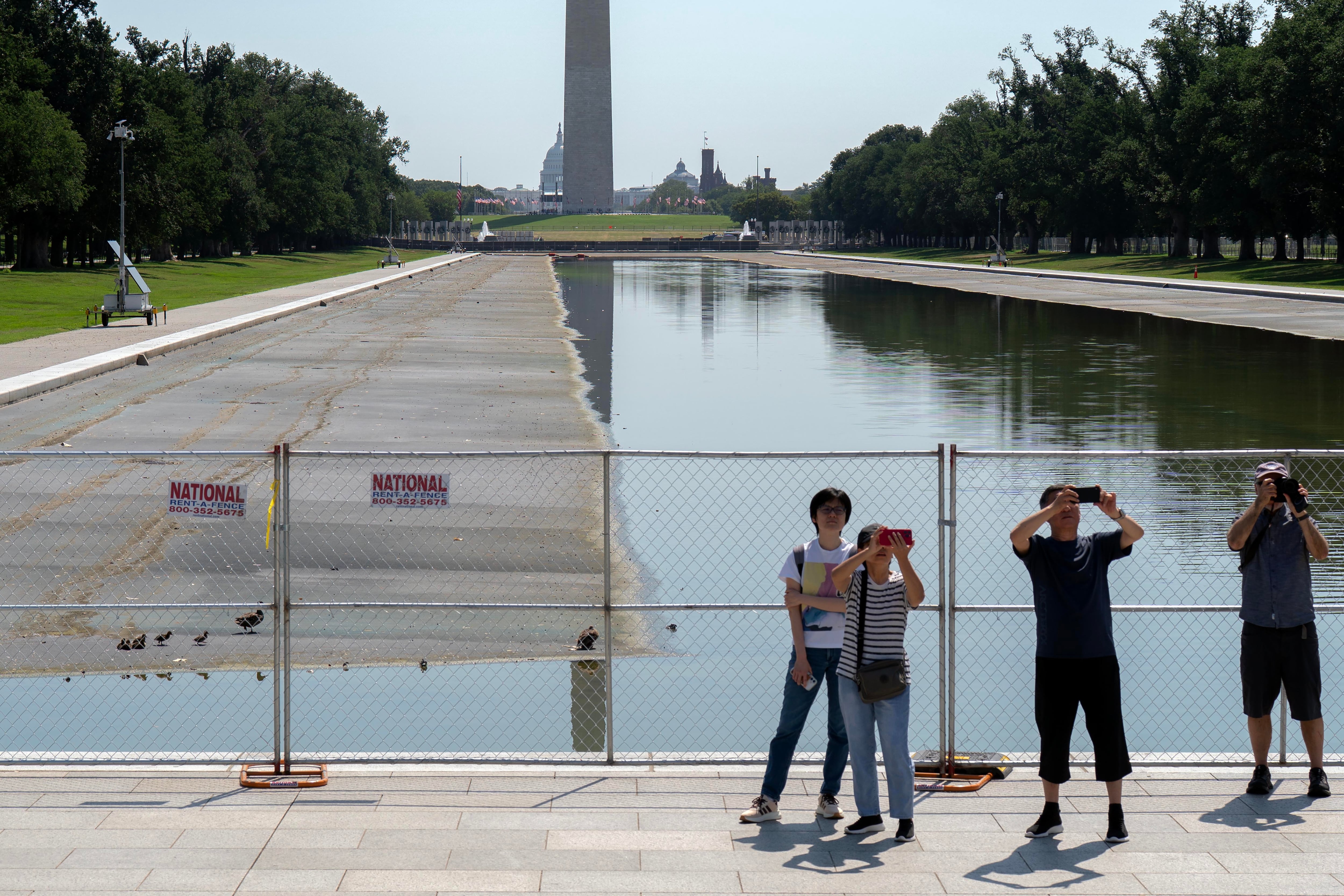 Varias personas se detienen para tomar fotografías junto al estanque reflectante del Monumento a Lincoln (Foto AP/Jose Luis Magana)