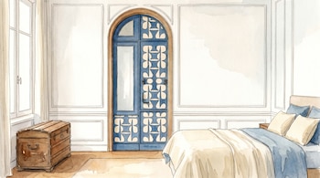 Una ilustración de acuarela de un dormitorio con paredes blancas y paneles, una puerta azul arqueada central, una ventana, un baúl y una cama.