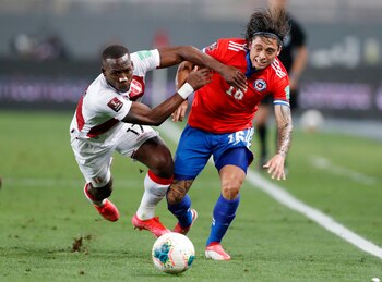 Luis Advíncula y Joaquín Montecinos disputando un balón en el Perú vs. Chile de la fecha 11 de las Eliminatorias. | Foto: REUTERS