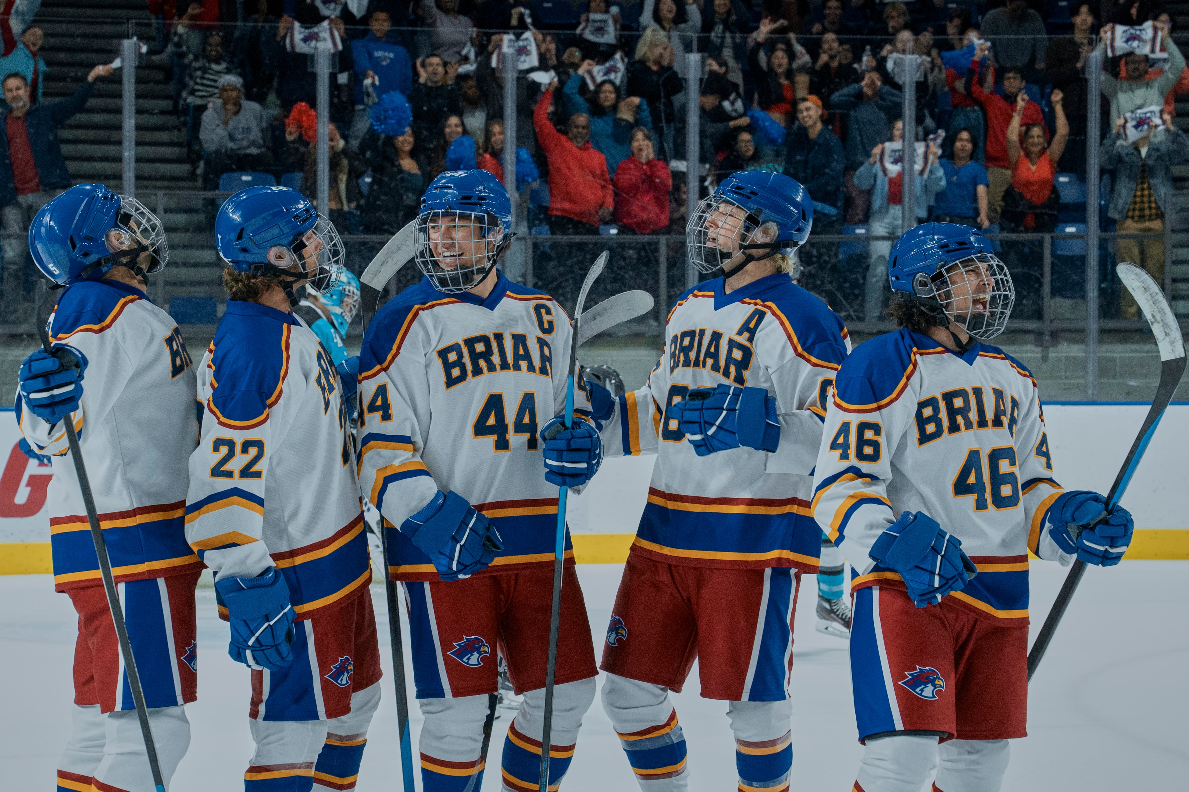 Los jugadores del equipo de hockey de Briar, de la popular serie Off-Campus, comparten un momento en la pista de hielo mientras el público los anima. (Prime video)