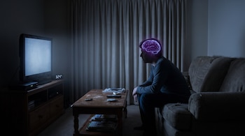 Un hombre sentado en un sofá oscuro frente a un televisor encendido con estática; su cerebro se ilumina en color morado. Un reloj marca las 3:24 AM.