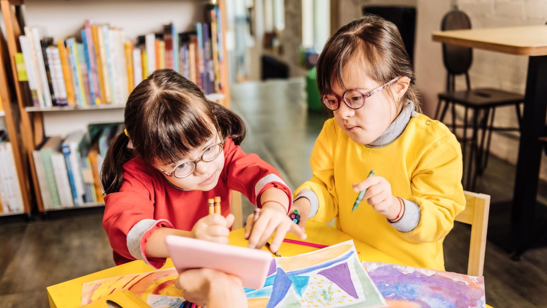 Dos niñas con síndrome de Down en un centro educativo. (Canva)
