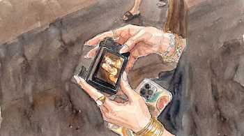Ilustración en acuarela de unas manos con anillos y pulseras sujetando una cámara digital que muestra dos mujeres en pantalla, y un smartphone.