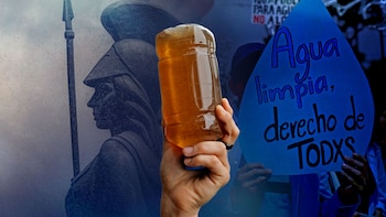 Una mano sostiene una botella con agua turbia junto a un cartel azul con forma de gota y la silueta de una escultura en el fondo