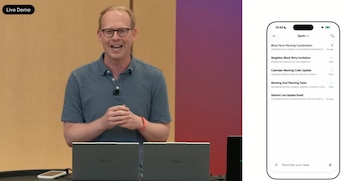 Josh Woodward, vicepresidente de Google Labs, sonríe en un escenario. Sobre la mesa hay dos laptops y un smartphone blanco. A la derecha, la interfaz móvil de la app Gemini en pantalla