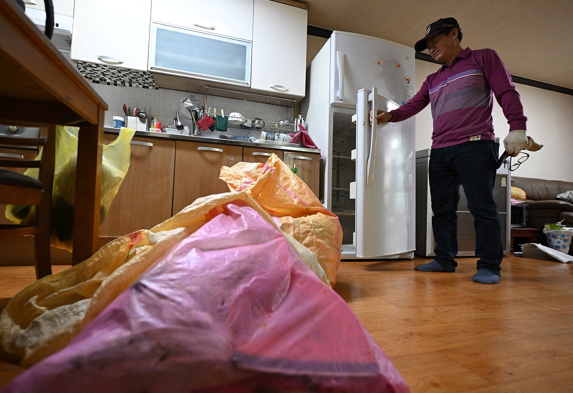 Kim Seok-jung, una limpiadora que acondiciona casas tras el fallecimiento de sus ocupantes —a menudo personas que vivían solas—, limpia la habitación de una mujer de casi 90 años que había fallecido recientemente en Chungju. (Foto de Jung Yeon-je / AFP)