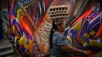 ‘En mi vida hubiera pensado meterme aquí’: Muralistas cambian marcas de las pandillas por arte en un barrio de El Salvador