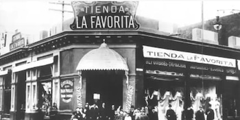 Fachada de una tienda llamada La Favorita con grandes ventanales, toldos, personas en la entrada y un cartel luminoso en blanco y negro