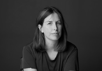 Retrato en blanco y negro de una mujer con cabello oscuro a la altura de los hombros y camiseta oscura frente a un fondo neutro