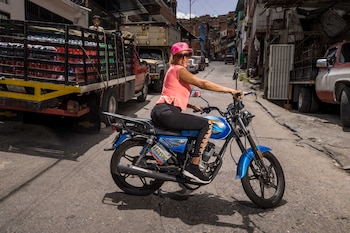 Fotografía del 27 de junio de 2024 de Ninoska Bello posando tras una clase sobre mecánica para motorizadas en Petare, la barriada más grande de Caracas (Venezuela). EFE/ Miguel Gutiérrez