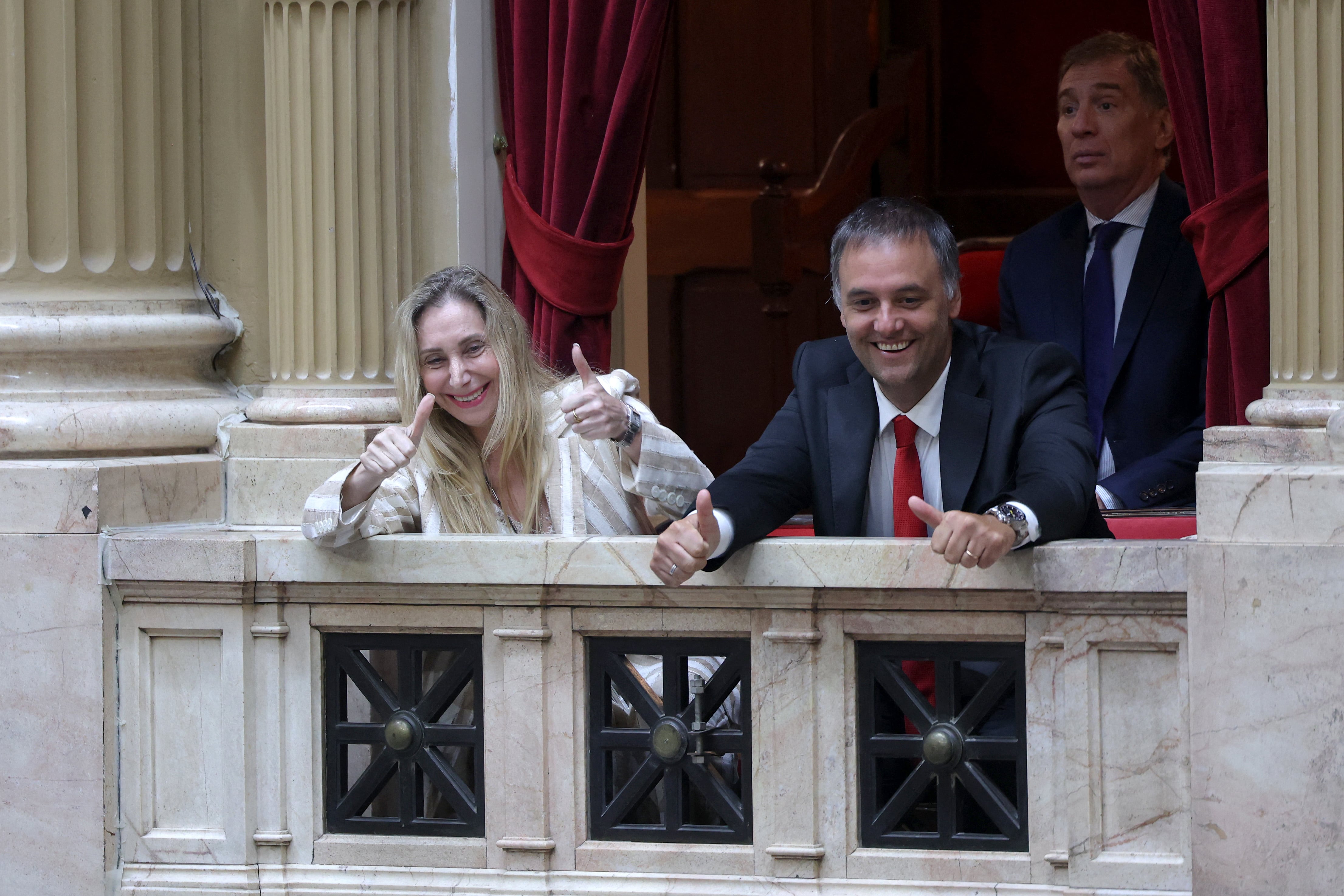 La secretaria general de la Presidencia, Karina Milei, posa junto al jefe de Gabinete, Manuel Adorni, en el Congreso. Atrás suyo, el ministro del Interior, Diego Santilli (AFP)