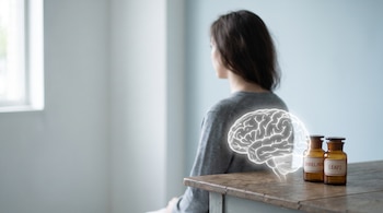 Una joven adulta de espaldas, una silueta translúcida de cerebro y dos frascos etiquetados ghrelina y LEAP2 sobre una mesa.