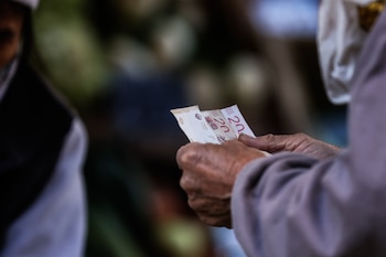 Según cifras oficiales, el conjunto de alimentos y bebidas registró en septiembre un aumento interanual de precios del 53,4 % y un alza acumulada en lo que va del año del 36,6 %. En la imagen un registro de archivo de un ciudadano al contar billetes mientras compra alimentos en Buenos Aires (Argentina). EFE/Juan Ignacio Roncoroni
