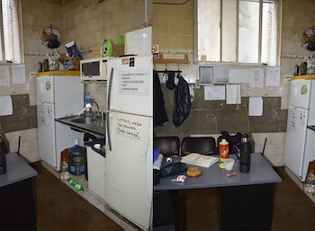 Dos vistas de un sector con heladeras, fregadero, carteles pegados en la pared y una mesa con papeles y un termo