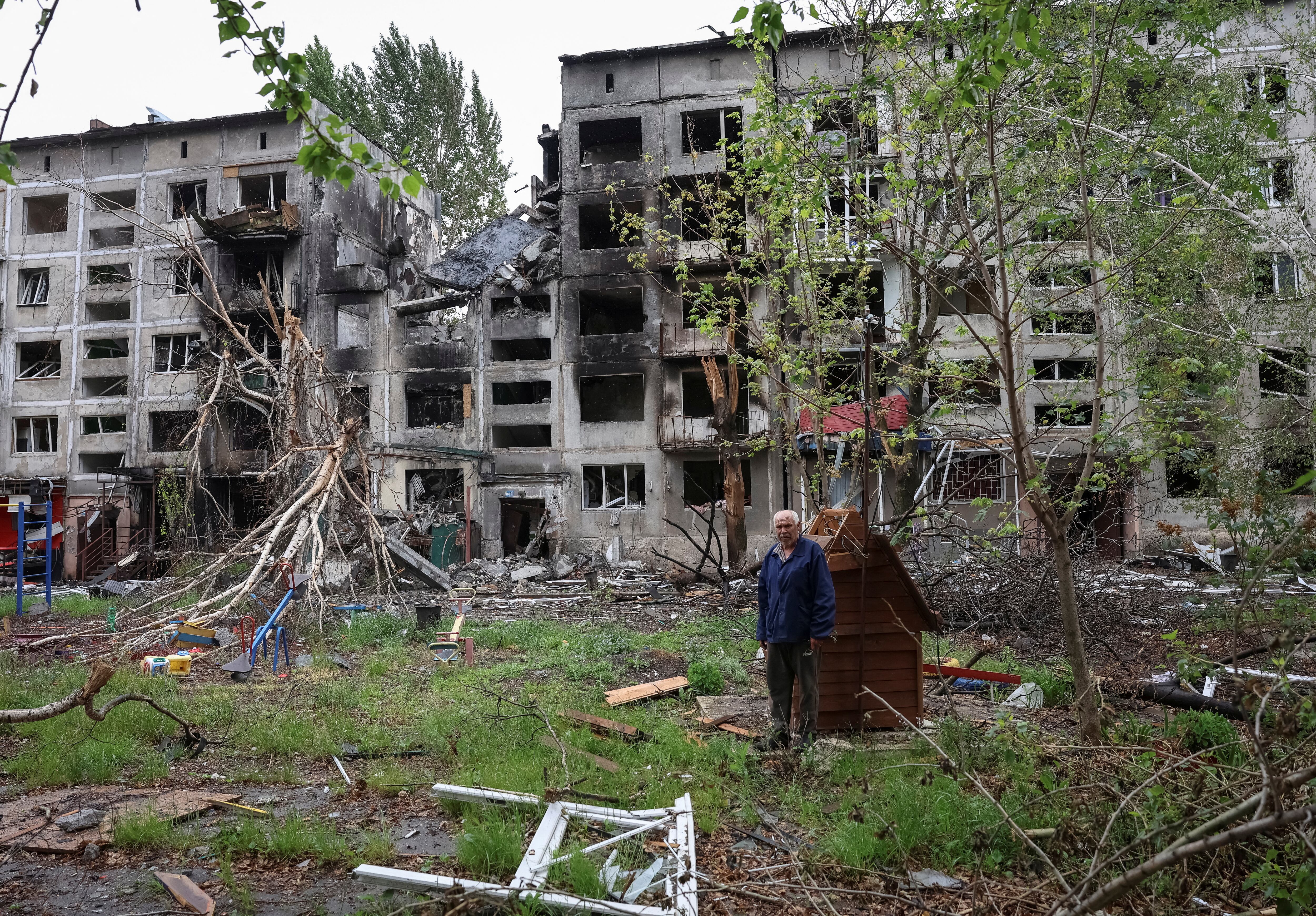 Un residente se encuentra cerca de edificios dañados por los ataques militares rusos en Myrnohrad, región de Donetsk (REUTERS/Anatolii Stepanov)
