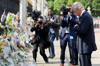 Carlos observa los ramos de flores (REUTERS/Toby Melville)