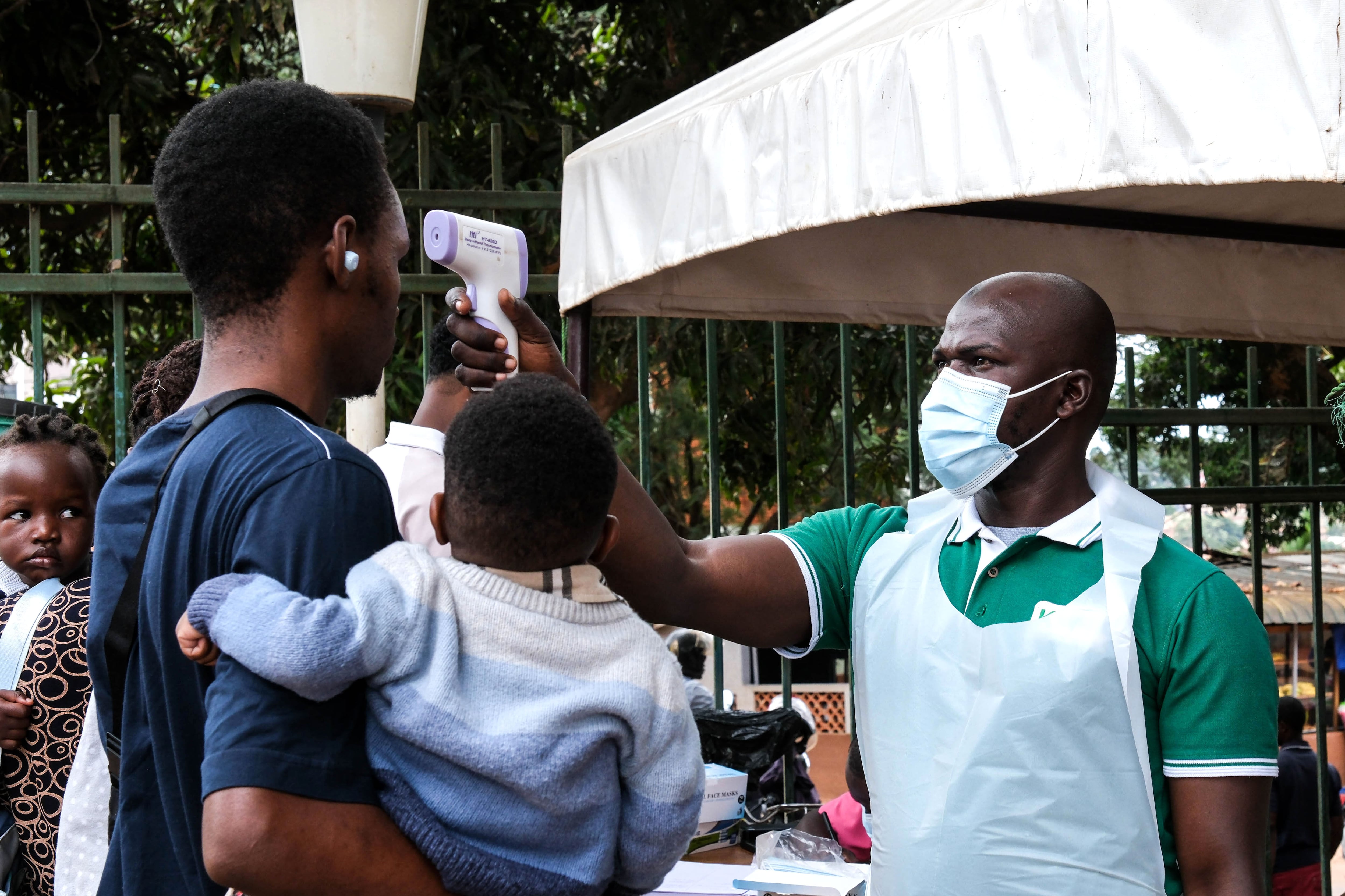 Un funcionario de salud utiliza un termómetro para tomar la temperatura a las personas frente al Hospital Musulmán de Kibuli, en Kampala, Uganda, el sábado 16 de mayo de 2026. (AP Foto/Hajarah Nalwadda)