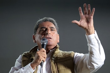 Carlos Álvarez, un hombre de mediana edad con cabello gris, habla en un micrófono, vistiendo camisa blanca y chaleco marrón, gesticulando con su mano derecha