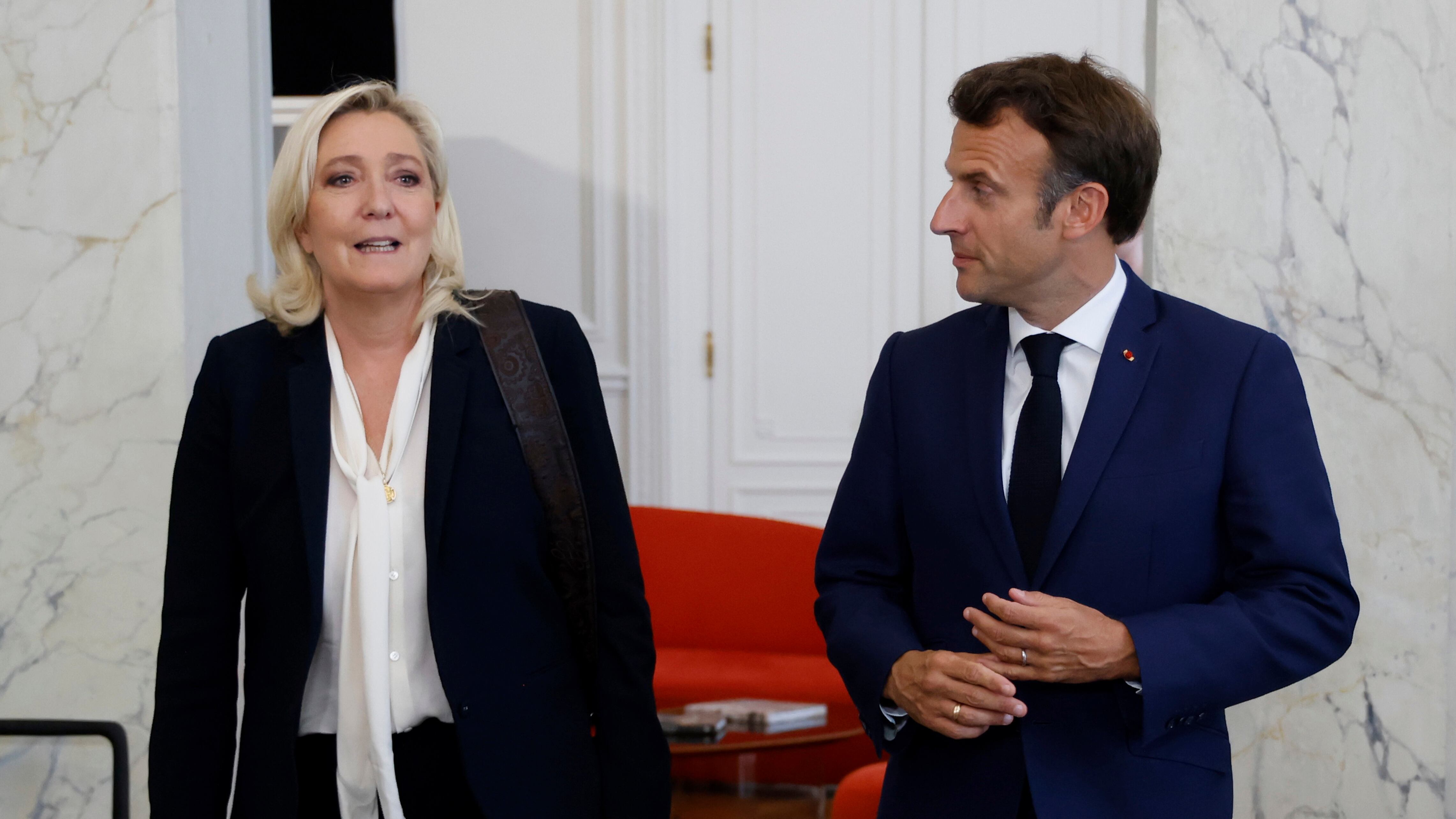 El presidente de Francia, Emmanuel Macron, a la derecha, junto con la líder del grupo de ultraderecha francés Agrupación Nacional, Marine Le Pen (Ludovic Marin/Pool foto via AP, Archivo)