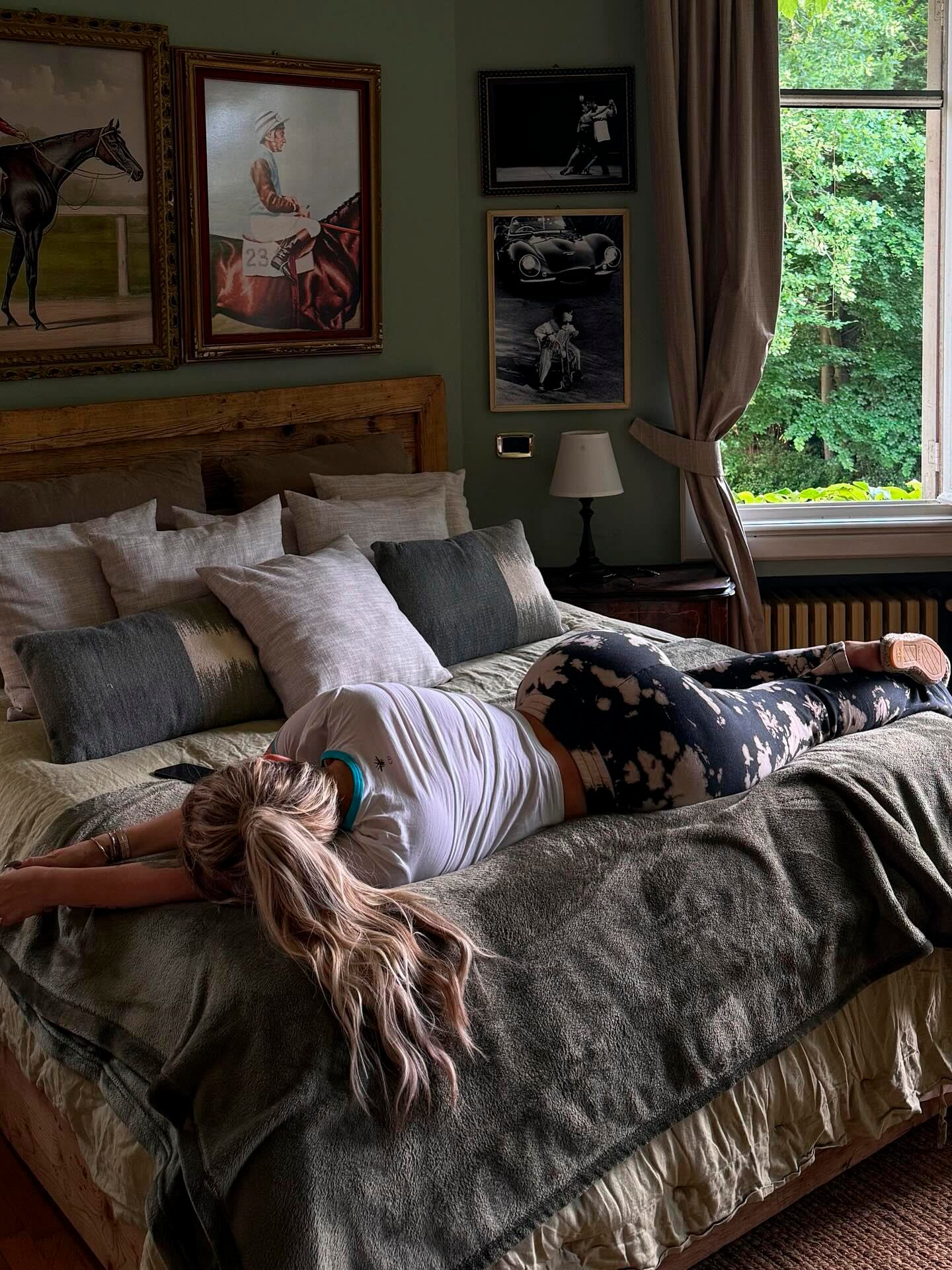 Wanda estirada sobre su cama repleta de mantas y almohadones