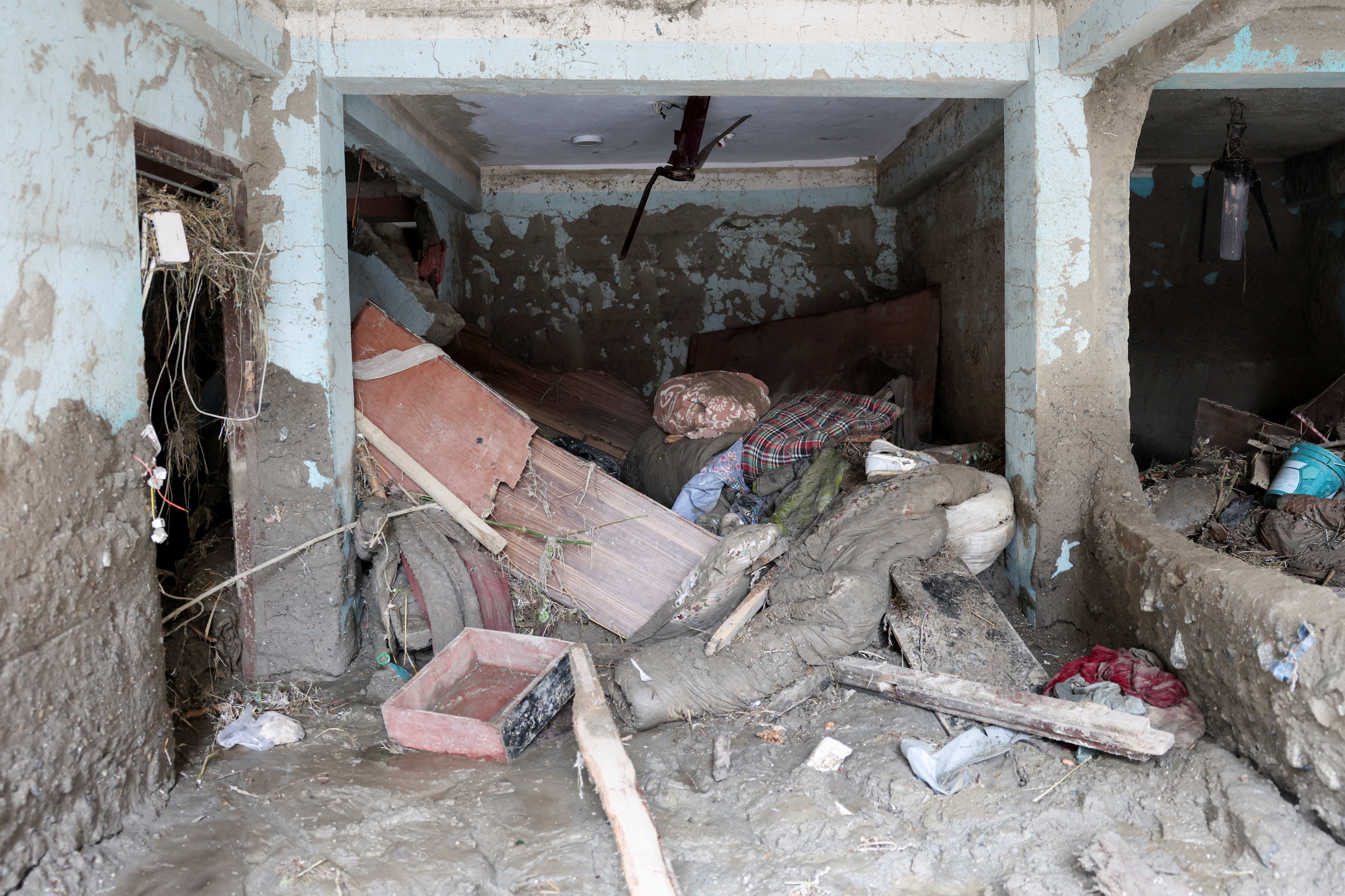Muebles dañados y otras pertenencias cubiertas de barro se amontonan en el interior de una vivienda afectada tras las inundaciones repentinas y el deslizamiento de tierra en Devighat, distrito de Nuwakot, Nepal, el 29 de agosto de 2026 (REUTERS/Adnan Abidi)