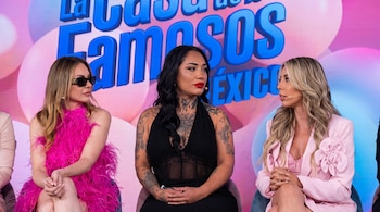 Tres mujeres están sentadas juntas frente a un fondo con el logotipo del programa La Casa de los Famosos México.