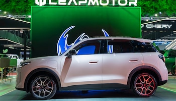 Un vehículo de color blanco visto de perfil frente a una pared verde con el nombre impreso LEAPMOTOR