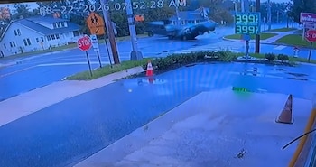 Imagen de una cámara de vigilancia durante la colisión de dos automóviles en una intersección cerca de una estación de servicio