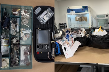 Una caja con llaves y herramientas, un dispositivo electrónico en su estuche y bolsas de basura negras con cartas sobre una mesa