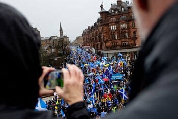 Demonstrators march with various flags