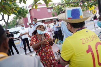 Óscar Iván Zuluaga hablando con la gente de Riohacha. Tiene una camiseta de la selección y un sombrero de paja.
