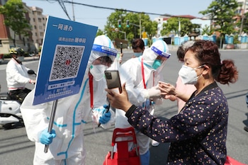 Trabajadores con trajes protectores inspeccionan