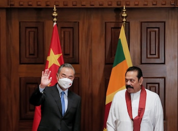 El ministro de Relaciones Exteriores de China, Wang Yi, saluda a las cámaras junto al entonces primer ministro de Sri Lanka, Mahinda Rajapaksa (REUTERS/Dinuka Liyanawatte)