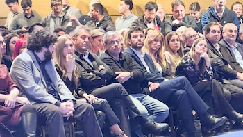 Un grupo de personas permanece sentado en las primeras filas de un auditorio