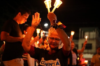 Una mujer sostiene un rosario