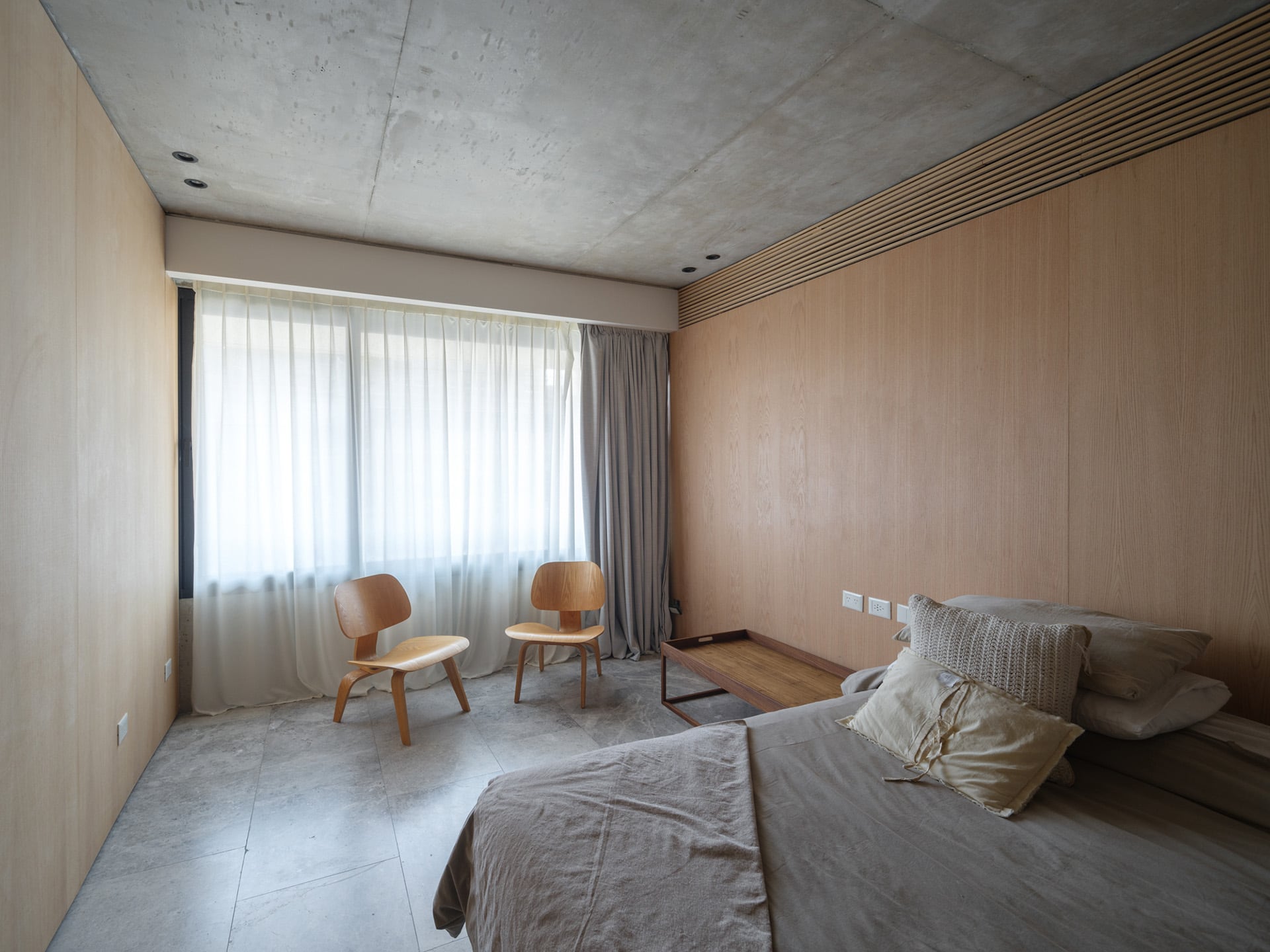 Las habitaciones y el lavadero en el nivel inferior mantienen una estética limpia gracias a puertas ocultas en madera de roble