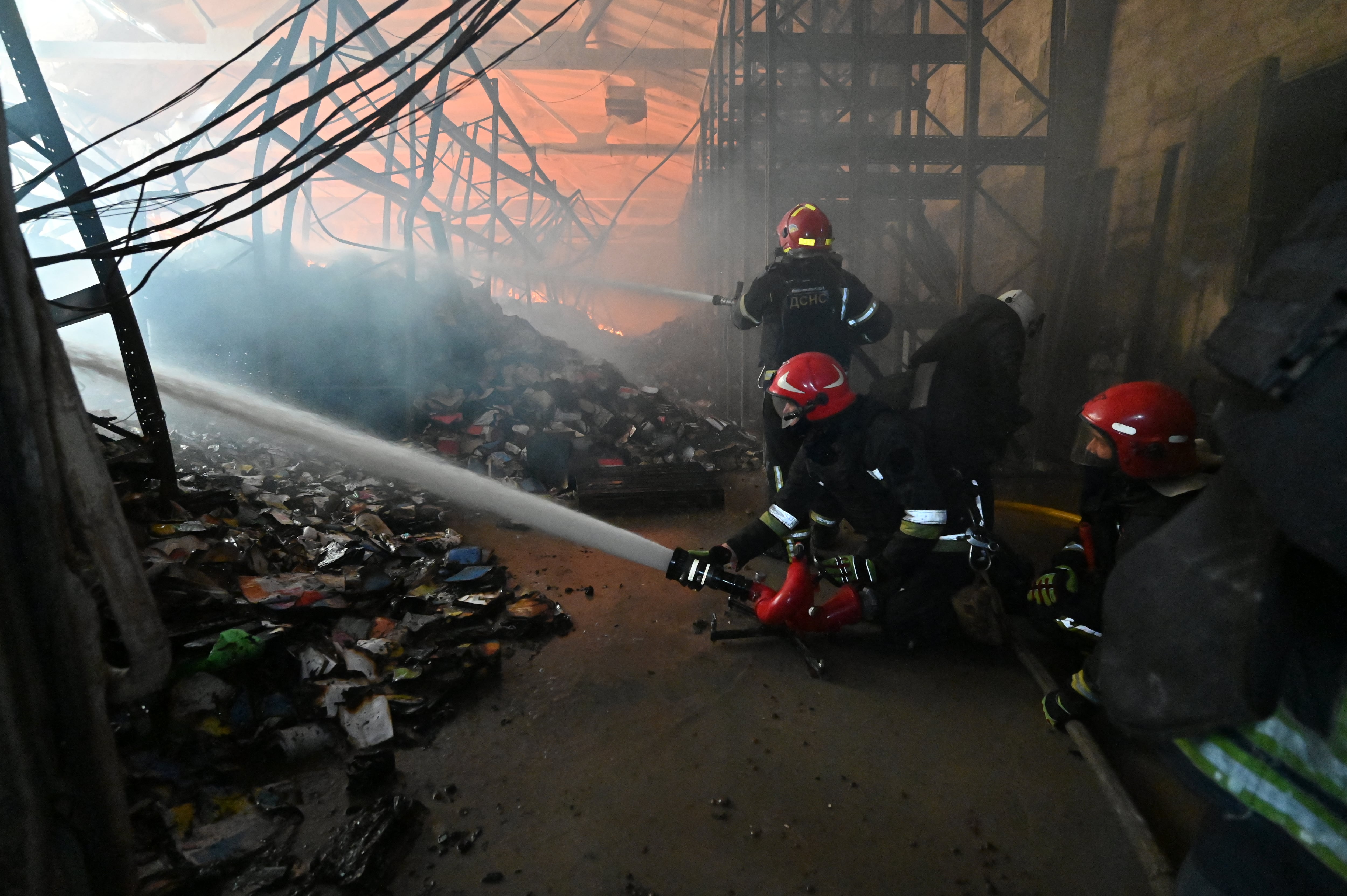 Bomberos extinguen un incendio en la zona dañada de una librería tras un ataque aéreo ruso en Járkov el 1 de agosto de 2026, en el marco de la invasión rusa de Ucrania (SERGEY BOBOK / AFP)