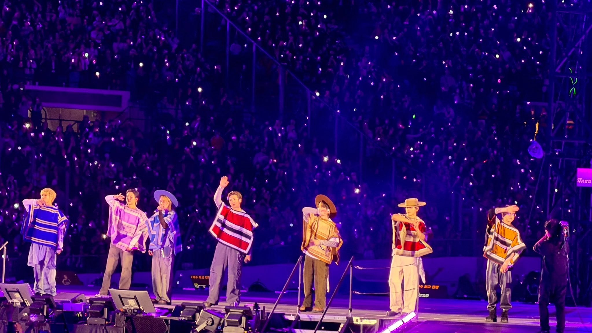 Los integrantes del grupo surcoreano BTS se presentan con ponchos tradicionales chilenos frente al público en el estadio de Santiago