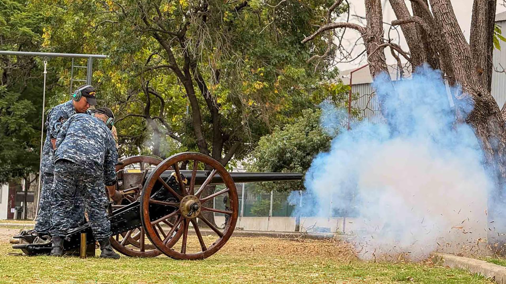 Dos operarios uniformados disparan un cañón antiguo, durante la ceremonia en la Plaza de Armas del Estado Mayor General de la Armada