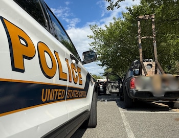 Patrulla de la Policía del Capitolio de Estados Unidos junto a una camioneta que transporta una guillotina de madera en la caja