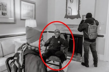 Imagen en blanco y negro de Elias Irizarry, con gorra, mascarilla y guantes, sentado en un sillón dentro del Capitolio durante el asalto, con otros dos hombres