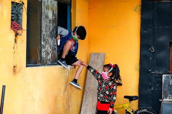 Niños con mascarillas juegan en