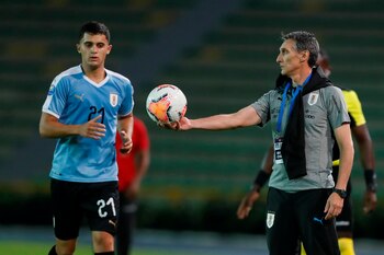 El entrenador de Uruguay Gustavo Ferreyra (d) entrega un balón a Agustín Oliveros. EFE/Ernesto Guzmán Jr/Archivo
