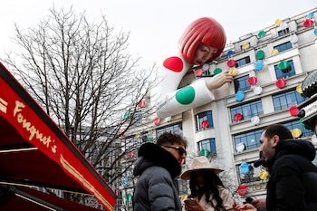 Instalación de un gran maniquí inflable que representa a la artista japonesa Yayoi Kusama, asomándose sobre la tienda insignia de Louis Vuitton en la avenida de los Campos Elíseos de París, Francia (REUTERS/Benoit Tessier)