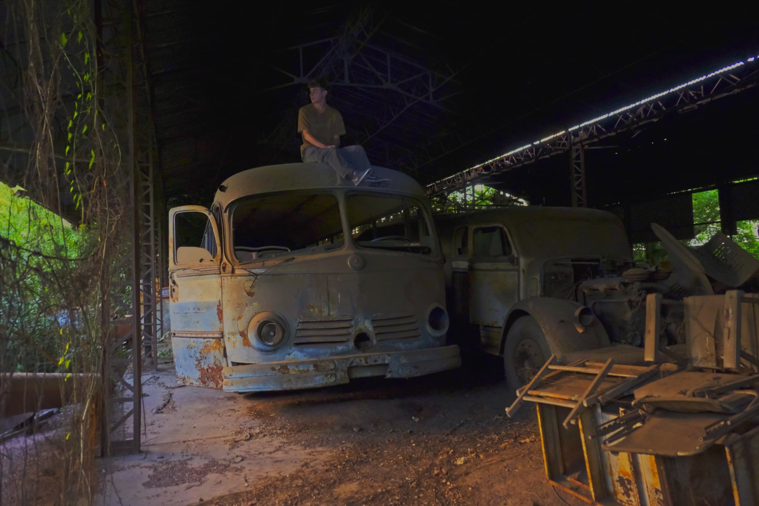 Ian Menéndez sobre un colectivo abandonado dentro de una fábrica