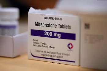 Caja blanca de Mifepristone Tablets 200 mg con letras negras y moradas en primer plano. Se observan indicaciones de dosificación y un logotipo