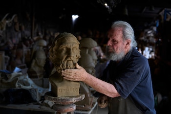 El escultor y ceramista Haralambos Goumas trabaja sobre un busto de terracota del antiguo poeta griego Homero, el autor de "La Odisea", en su taller Aigaleo, un suburbio de Atenas, el miércoles 27 de mayo de 2026 (AP Foto/Petros Giannakouris)