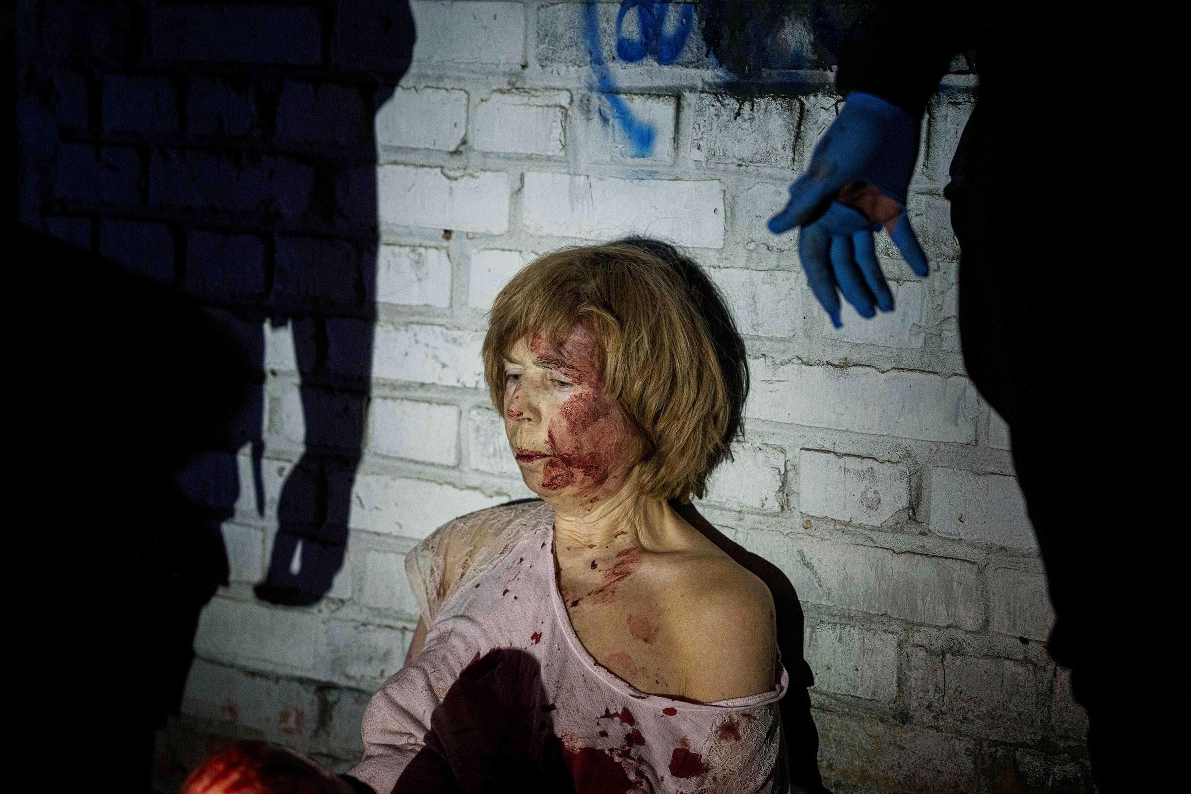 Una mujer herida se sentó cerca de su casa, dañada por un ataque aéreo ruso, en un barrio residencial de Kiev, Ucrania, el 24 de abril (Evgeniy Maloletka—AP)